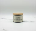 Fjell Dekor Euphoria 4oz limited edition beeswax candle in a black jar with a light wood lid on a marble surface.