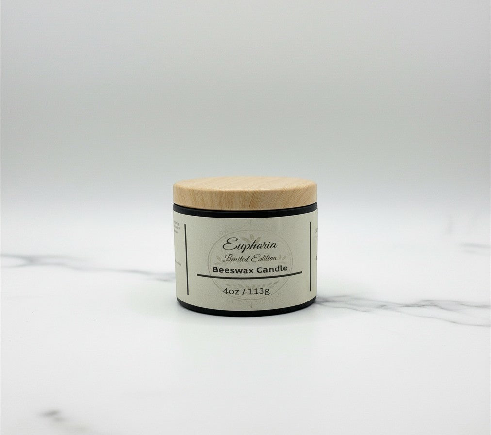 Fjell Dekor Euphoria 4oz limited edition beeswax candle in a black jar with a light wood lid on a marble surface.