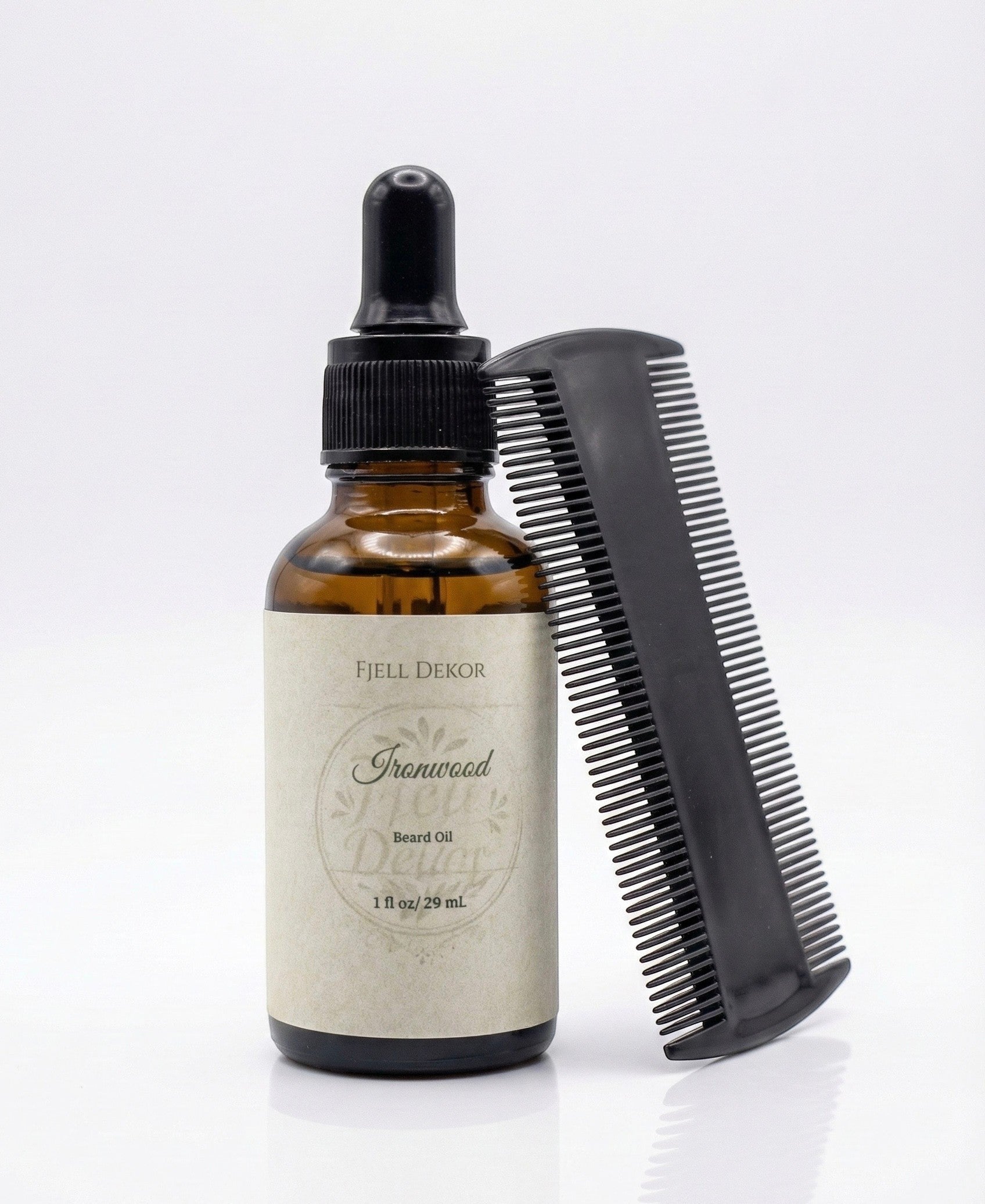 Fjell Dekor Ironwood 1oz beard oil in an amber glass dropper bottle with a black grooming comb on a white background.