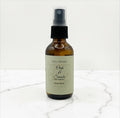 Fjell Dekor Oak and Smoke 2oz botanical body fragrance in an amber glass spray bottle on a white marble surface.
