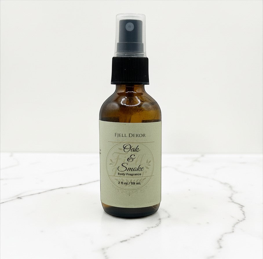 Fjell Dekor Oak and Smoke 2oz botanical body fragrance in an amber glass spray bottle on a white marble surface.