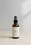Fjell Dekor Velvet Blossom 2oz botanical body fragrance in an amber glass spray bottle on a light wooden surface.